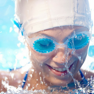 woman wearing head cap and swimming glasses close-up smile pool | Holmes Place